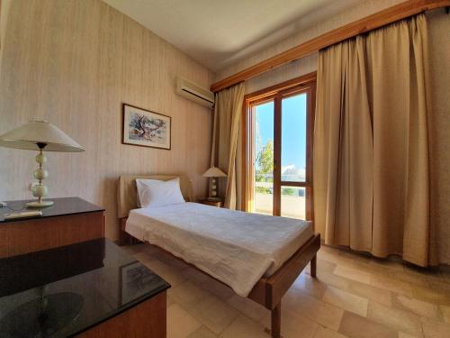 a bedroom with a bed and a large window at Hotel Elman in Palaiochóra