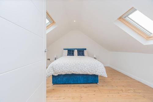 a bedroom with a bed in a white room at 4 Bed cottage with Hot tub in Bannockburn