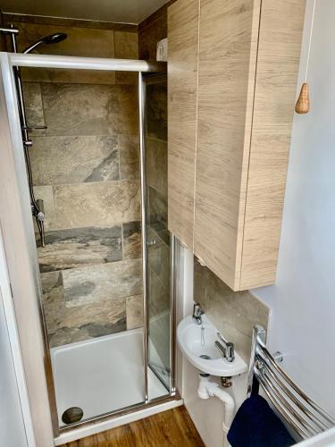 a bathroom with a shower and a sink at 'The Wheelhouse' Nautically themed with large sleeping deck in Southwold