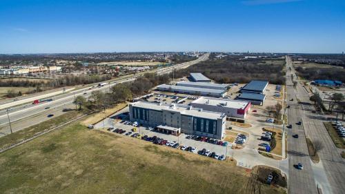 an aerial view of a building and a parking lot at WoodSpring Suites Dallas Plano Central Legacy Drive in Plano