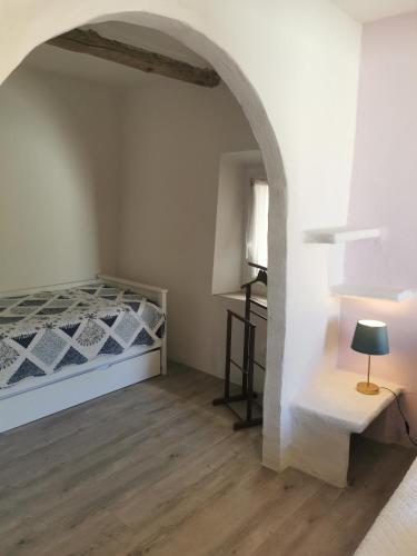 a bedroom with a bed and a table in a room at 1832 La Rabassière in Malaucène
