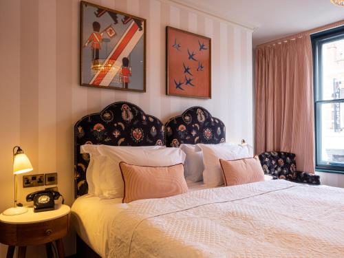 a bedroom with a large bed with a black headboard at Spread Eagle in London