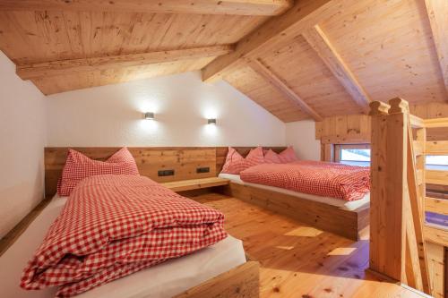 two twin beds in a room with wooden ceilings at Kaser Premium Chalet am Berg in Neustift im Stubaital