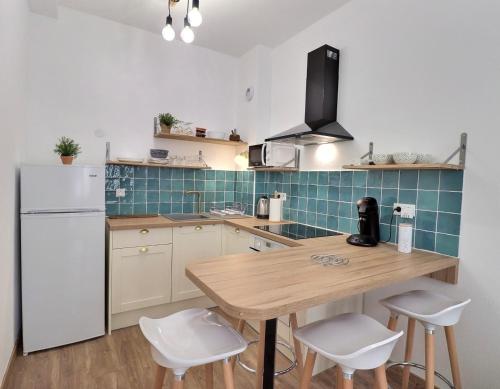 une cuisine avec une table en bois et un réfrigérateur blanc dans l'établissement Superbe appartement, à Marseille