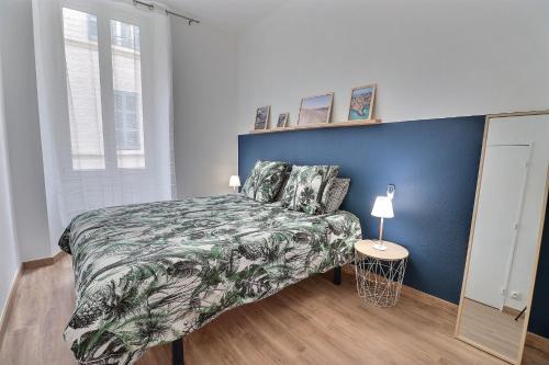 1 dormitorio con cama y pared azul en Superbe appartement, en Marsella