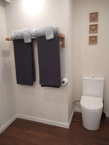 a bathroom with a toilet and towels on a wall at Casinha Secreta - A Gema Escondida da Santa Luzia in Santa Luzia