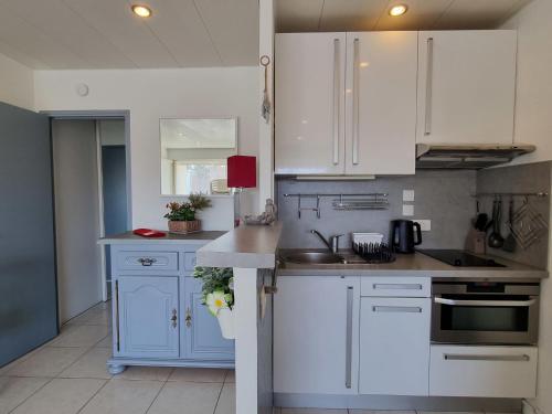 una cocina con armarios blancos y fregadero en Apartment De la Plage-1 by Interhome, en Cavalaire-sur-Mer
