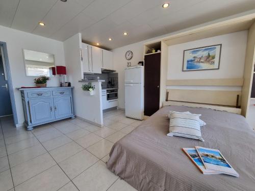 1 dormitorio con 1 cama y cocina con nevera en Apartment De la Plage-1 by Interhome, en Cavalaire-sur-Mer