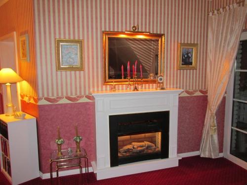 a living room with a fireplace and a mirror at Pension Roseneck in Wolfshagen