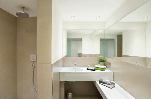 a bathroom with a sink and a mirror at Hotel Hohe Linde in Isny im Allgäu