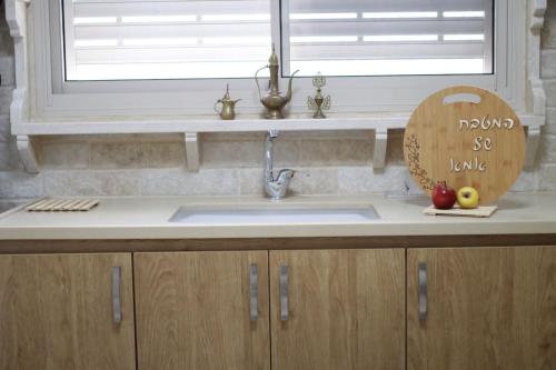 eine Küchentheke mit einem Waschbecken und einem Fenster in der Unterkunft Hala Castel - Luxury villa for families & couple's in Yānūḥ