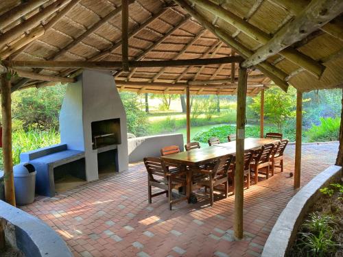 a patio with a wooden table and a fireplace at Pine Valley in Lanseria