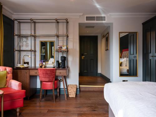 a bedroom with a desk and a bed and a room with a bed gmaxwell gmaxwell at Spread Eagle in London