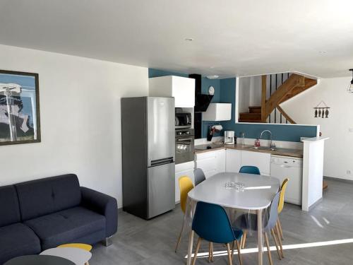 un salon avec une table et une cuisine dans l'établissement maison totalement rénovée 3 chambres au coeur du village, à Lézardrieux