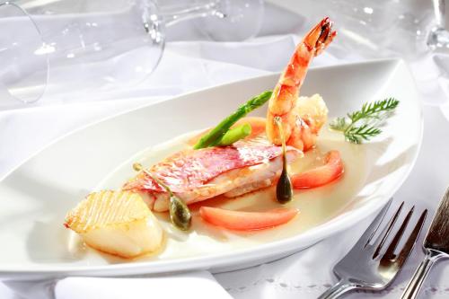 a plate of food with shrimp and vegetables on a table at Hotel Hohe Linde in Isny im Allgäu