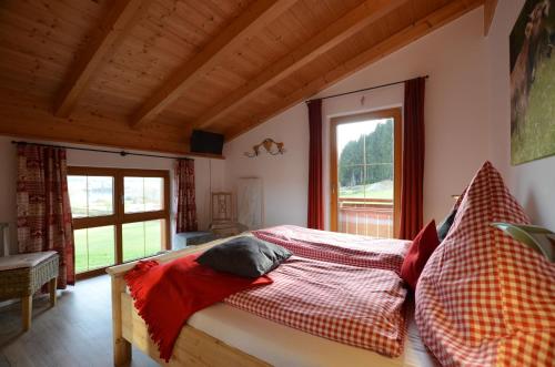 a bedroom with a bed in a room with windows at Feriendorf Via Claudia Haus 59 Gamsbock in Lechbruck