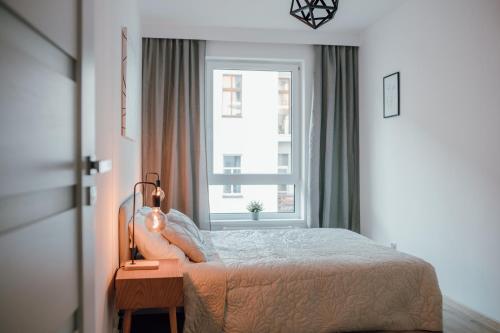 a bedroom with a bed and a window at Złote Apartamenty 36 in Legnica