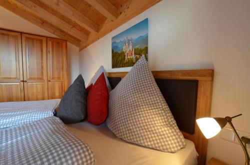 a bedroom with a bed with pillows on it at Feriendorf Via Claudia Haus 82 Alpensee in Lechbruck