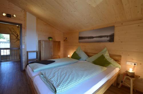 a bedroom with a bed in a wooden room at Feriendorf Via Claudia Haus 75 Waldromantik in Lechbruck