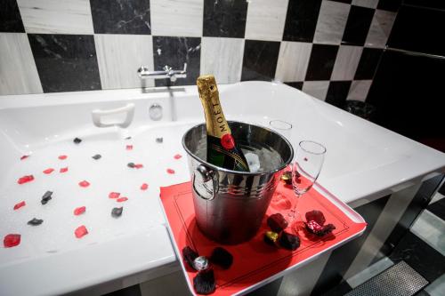 a bucket of wine on a table next to a bath tub at Motel Venus Pontevedra in Poio