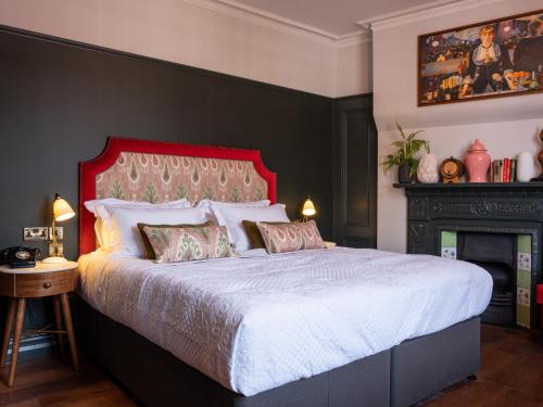 a bedroom with a large bed and a fireplace at Spread Eagle in London