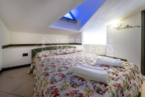 a bedroom with a bed with towels on it at 18 BAIA FARO - Grazioso bilocale mansardato a Baia del Faro in Palau