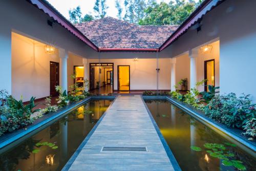 Kaliyal的住宿－Vaikundam Legacy，一座房子前面设有游泳池