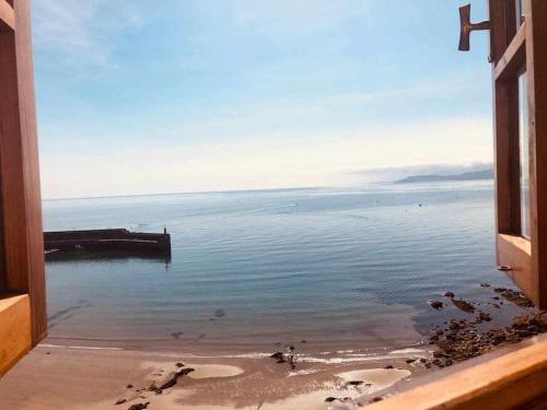 a view of the ocean from a window at La casina de La Fragua in Lastres