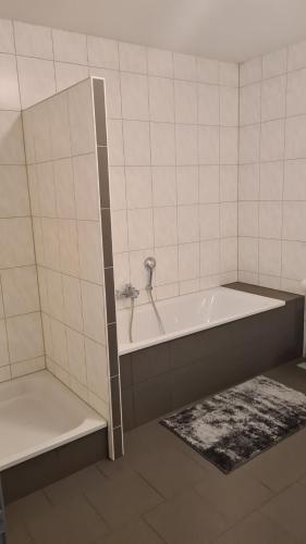 a bathroom with a tub and a toilet and a rug at Familien-Ferienwohnung Fiwa FeWo-4 in Pirmasens
