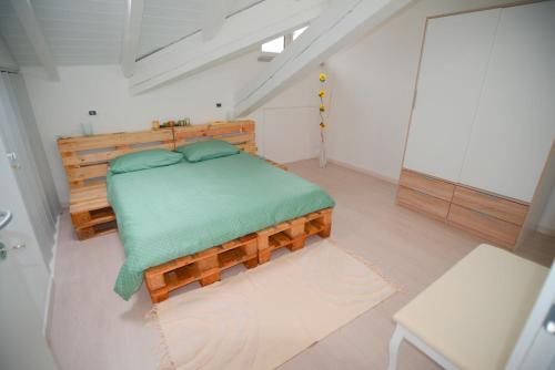 a bedroom with a wooden bed with a green blanket at Ca' Mari in Gravellona Toce