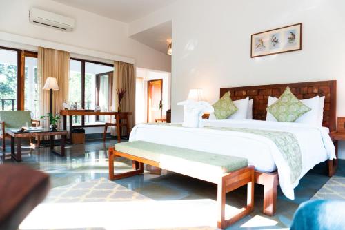 a bedroom with two beds and a living room at Saraca Resort & Spa Corbett in Garjia