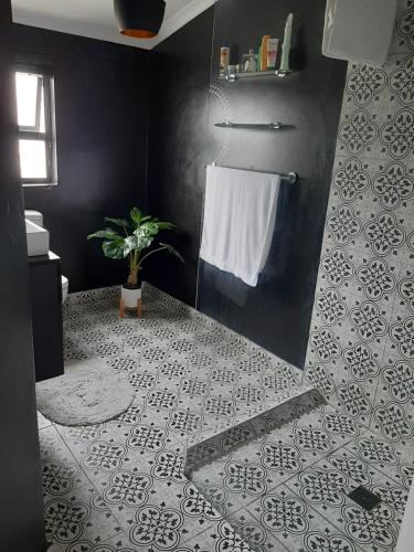 Łazienka z prysznicem wyłożona jest czarno-białymi kafelkami. w obiekcie White house w Kapsztadzie