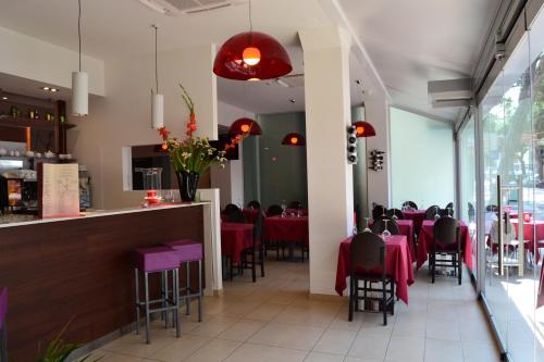 jadalnia z czerwonymi stołami i krzesłami w obiekcie Hotel Morena w mieście Lido di Jesolo