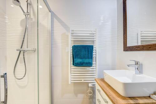 biała łazienka z umywalką i prysznicem w obiekcie Les Nards w mieście Praz-sur-Arly