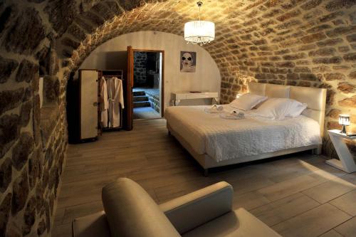 a bedroom with a bed and a brick wall at La Castanea Gîte de charme in Sanilhac