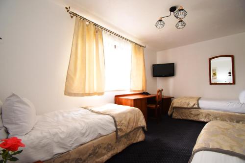 a hotel room with two beds and a window at Kraina Jezior in Ostróda