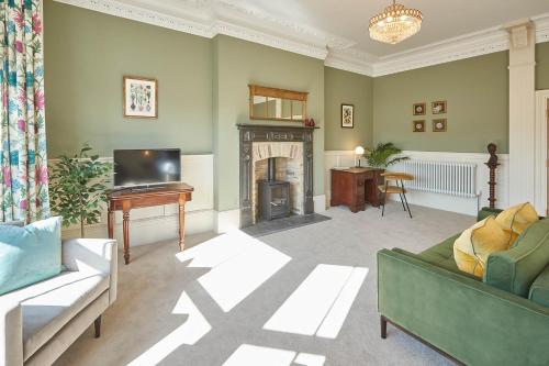 a living room with a couch and a television and a fireplace at Host & Stay - Milton Street Apartments in Saltburn-by-the-Sea