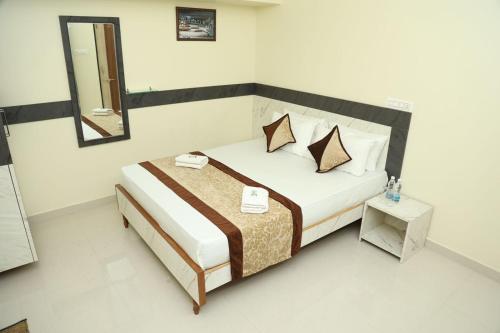 1 dormitorio con cama con espejo y mesa en M R Residency Belagavi, en Belgaum