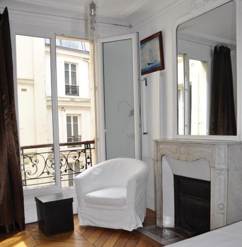una silla blanca en una habitación con chimenea en Plein centre, en París