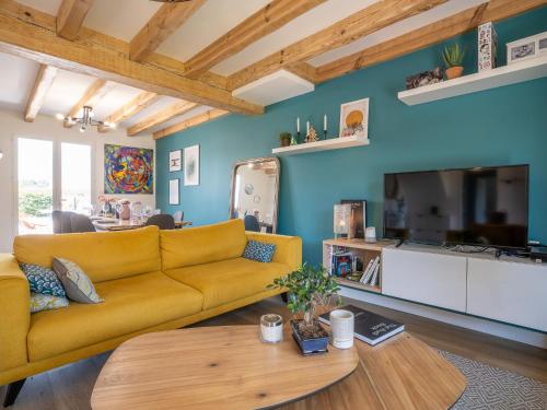 ein Wohnzimmer mit einem gelben Sofa und einem Tisch in der Unterkunft Holiday Home Chuchunieko by Interhome in Bidart