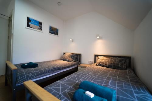a bedroom with two beds and a chair at Sea Bed Guesthouse in Newquay