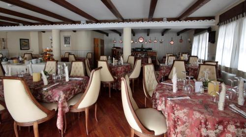 a dining room with tables and chairs in a room at Hotel La Meridiana in Madesimo