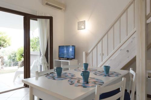 a dining room with a white table and a television at CHIA HOMES in Chia