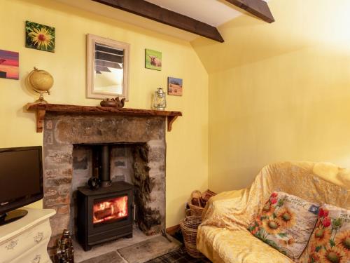 a living room with a fireplace and a tv at Holiday Home Deveron Valley Cottages by Interhome in Marnoch