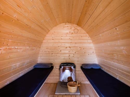 a wooden sauna with two benches and a bucket in it at Holiday Home Green Resort Mooi Bemelen by Interhome in Bemelen