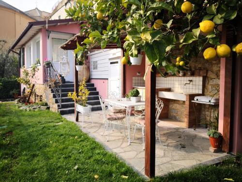 a table and chairs under an orange tree in a yard at Florinda Lemon's Suite in Cervo
