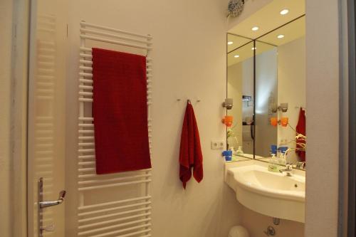 uma casa de banho com um lavatório e uma toalha vermelha em Strandstraße 16 Wohnung 06 em Kühlungsborn