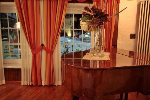 a vase of flowers on a table in front of a window at Hotel La Meridiana in Madesimo
