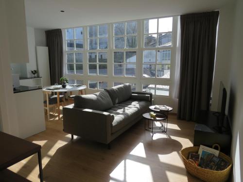 uma sala de estar com um sofá e uma grande janela em APARTAMENTOS ARMANYA 3 em Lugo