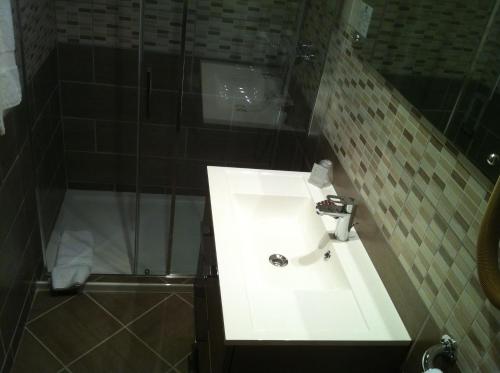 a bathroom with a sink and a shower at Les Tilleuls Montbeliard Sud Audincourt in Audincourt